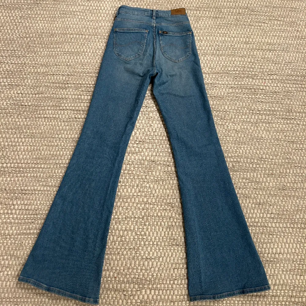Blåa bootcut jeans från Lee, höga i midjan. Som nya, använda ca 2 gånger. Storlek W25L31 200kr. Jeans & Byxor.
