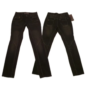 "ONE OF A KIND" JEANS - HELT NYA - Unika jeans från danska Share Female (märket försvann för ca 10 år sen). Gråsvarta med sömmar i silver och coola detaljer, ej riktig ficka mitt på bak. Midja: 78 cm, inre benlängd: 82 cm, midja fram/skrev: 22 cm, midja bak/skrev: 32 cm. Nypris: 799:-