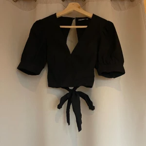 Söt blus - Söt svart blus med v-ringning och öppen rygg med knyte! Strl XS