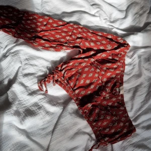 Enärmad topp - Enärmad röd topp med mönster. Strl. S. Köpt utomland och aldrig använd 