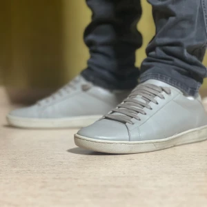 Saint Laurent skor - Ett par grå saint Laurent sneakers utan box . Skorna har en enkel och stilren design med en vit sula. mitt pris 2249 storlek 44