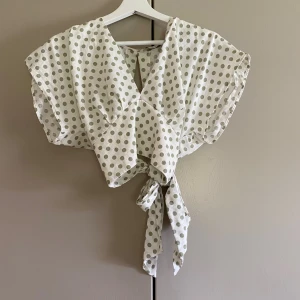 Gullig topp - Säljer en topp från zara som blivit för liten men som är i väldigt gott skick. V-ringad blus med knyte i ryggen. Storlek M. Säljer den för 150 kr + frakt 
