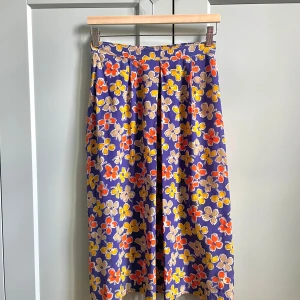 Vintage Silk Floral Skirt - Vintage Purple Floral Printed Skirt w frontal pleating. Side Button and Zip Closure. Some color transfer in a white area, not visible when worn. Very Good Condition. Unlined. Best Fits M  Model is 160cm (5”3) and generally fits XS/S.  100% Silk