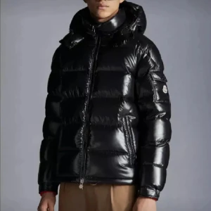 Svart pufferjacka från Moncler - En svart pufferjacka från Moncler med dragkedja och huva. Jackan har en glansig yta och är designad för att hålla värmen under kalla förhållanden. kvitto finns helt äkta, inga skador