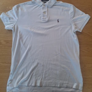 Polo ralph lauren piké  - Polo ralph lauren piké. Den har ett knappt synligt hål men bortsett från det är den i bra skick, bara å skriva vid funderingar. Pris kan diskuteras