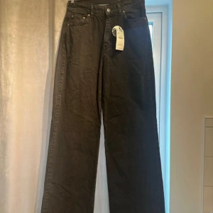 Jeans  - Svarta jeans Strandivarius  Storlek 40 passar även strl 38 Kvinna Midjemått: 72cm Innerbenslängd: 90cm Long Straight fit  Utsvängda och högmidjade