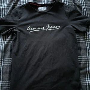 Armani Jeans T-Shirt - En fin vanlig armani jeans T-Shirt som passar i alla tilfällen. Den är i bra skick (9/10) och hade rekommenderats. Anledningen till att jag säljer denna tröjan är för att den är för kort i länge och armarna för mig. Pris går att diskuteras. 