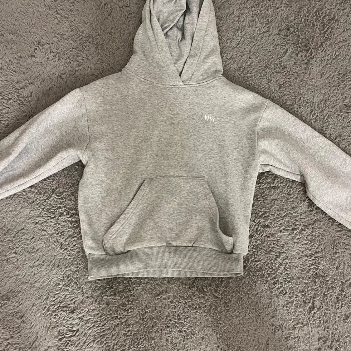 Grå Hoodie med NYC på tröjan.