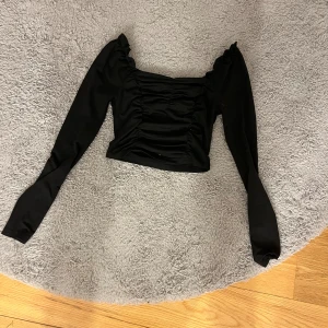 En svart långärmad tröja med design fram till. - Storlek S. Inte sp mycket använd så skulle säga helt okej skick