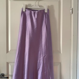 Satin kjol -  En medellång lila satin kjol Gina. Använd 1 gång.
