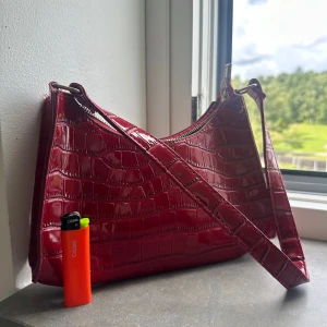 Röd ”skin” väska  - Köpt på second hand men jag har aldrig använt den.  I gott skick och har inga skavanker. 