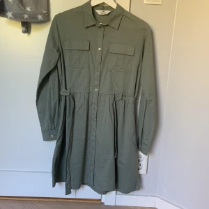 Skjortklänning  - En mörkgrön skjortklänning från H&M. Endast använd ett fåtal gånger. Då jag inte gillar den så mycket.
