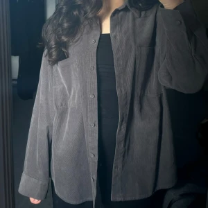 Oversized skjorta - Mörkgrå manchesterskjorta. Passar även som jacka vid varmare väder. Endast använd en gång. Fint skick. 