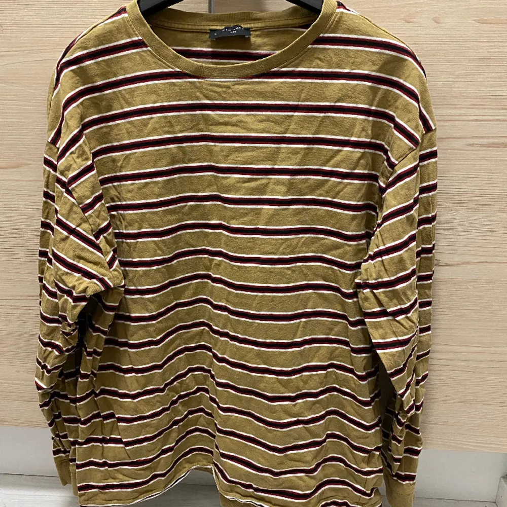 Långärmad tröja från New Look. Brun/beige, röd, svart och vit-randig.. T-shirts.