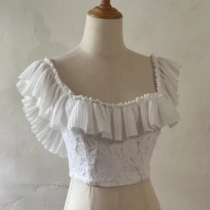 Vacker korsett-topp - Feminin topp med inbyggda korsettbågar och vacker spets. Perfekt vår/sommartopp! Köpt för 1 år sen och endast använd en gång, så i perfekt skick.