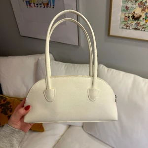 Liten vit väska - Väskan är så gott som oanvänd. Några små fläckar på innertyget finns🌷