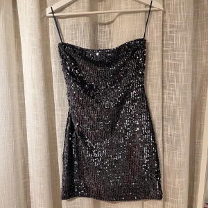 Paljettklänning  - Blå/grå, kort, axelbandslös paljettklänning från pull & bear. Storlek S men liten i storleken så den passar mig som normalt sett bär XS. Oanvänd med prislappen kvar. Använd gärna köp nu-funktionen❤️