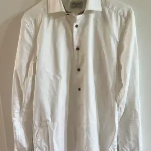Fin vit skjorta med exklusiva mönster i krage och ärm.  Stenströms Slimline twofold super cotton heter modellen och storleken är 37 och 14 1/2 i kragen.  Är du en M så kommer den sitta mer åt det tajtare hållet och är du en S så lite mer löst. 