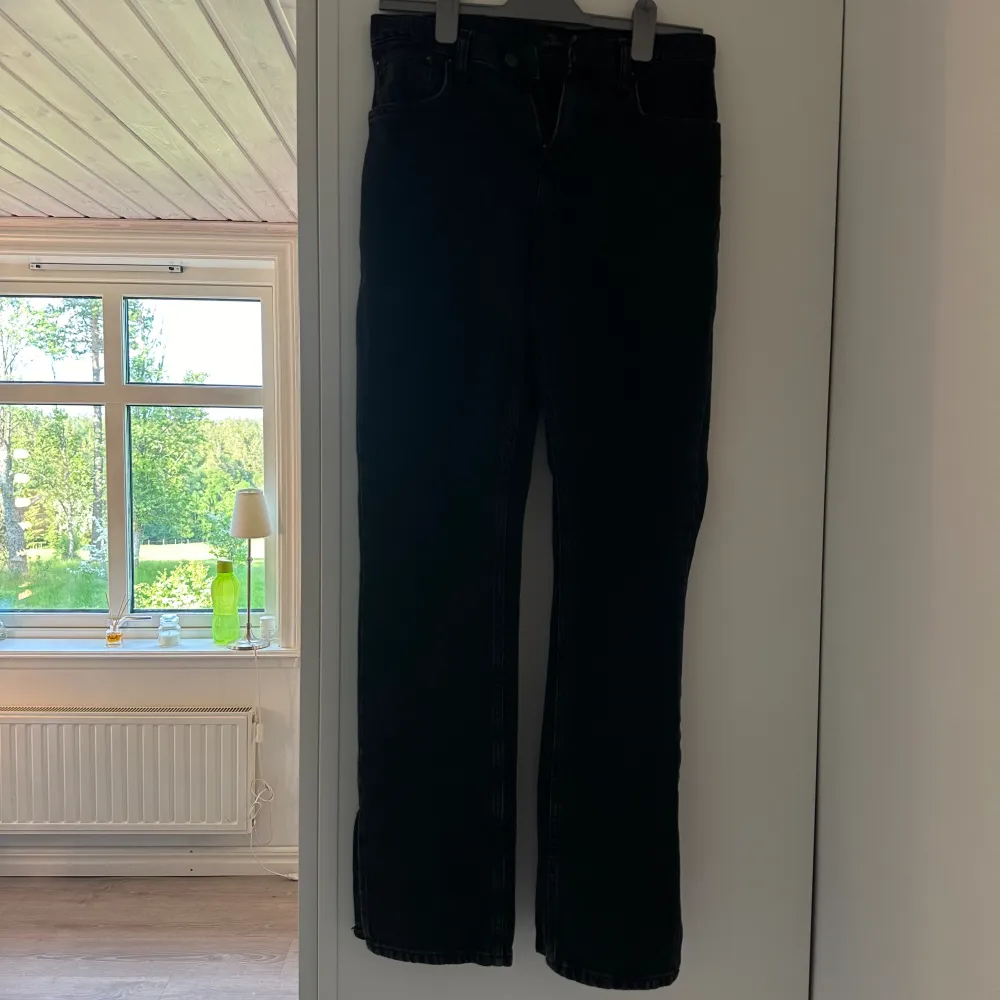 Snygga svarta jeans från Nelly med slits vid anklarna, bra skick!! Passar storlek 34/S Fraktkostnad kan tillkomma beroende på vart du bor. Jeans & Byxor.