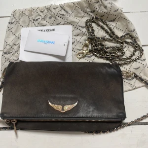 Zadig & Voltaire väska  - Säljer min väska då jag inte använder den så mycket längre. Den är i ko läder med gulddetaljer. En modell som inte går att få tag på längre. I använt skick därav priset. Äktsakpsbevis fins. Den var köpt för 3 300kr.