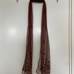 Skinny scarf - Säljer denna bruna skinny scarfen med pärl -och paljettdetaljer. Har du frågor eller önskar fler bilder är det bara att hmu så svarar jag så snabbt som möjligt!💞