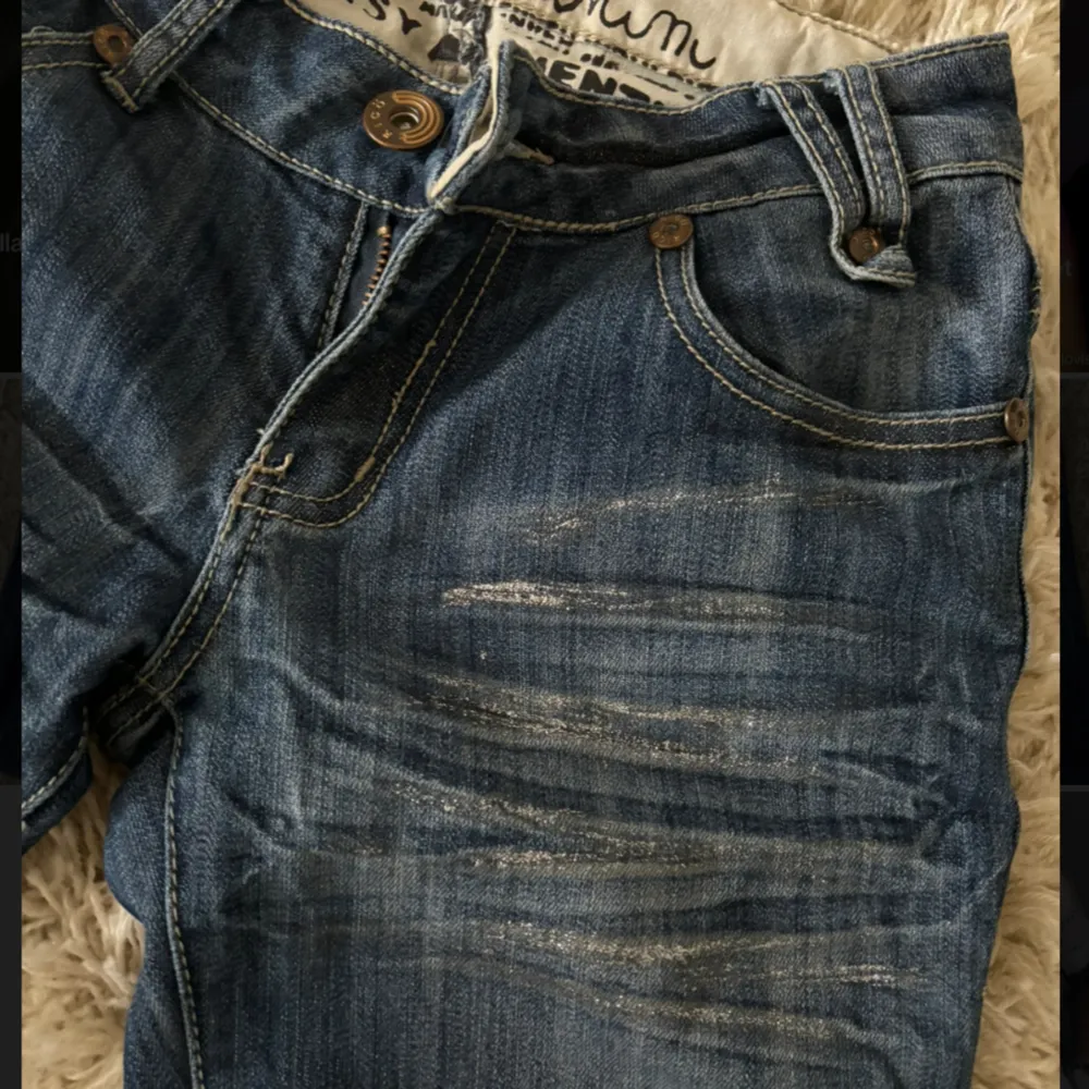 Supercoola blå lågmidjade jeans med voola silver detaljer längst benen! Unika bakfickor med knappar. Midjemått 37 och benlängt 101😋. Jeans & Byxor.