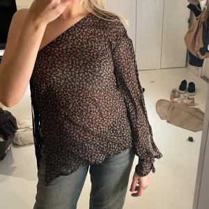 Blus  - En armad blus med slits och fransar 