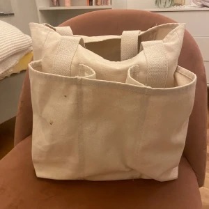 Snygg väska/tygpåse med 9 fack  - Snygg väska/tygpåse med 9 olika fack Passar perfekt som datorväska, gymbag, handväska eller när man reser!  Fin beige/linne färg