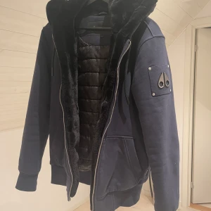 Moose Knuckle Hoodie jacka - Säljer nu min moose knuckles jacka som liknar en hoodie, köpt på nk för 4850kr tags finns och kvitto. för mer bilder är det bara att fråga. passar mig som har storlek M