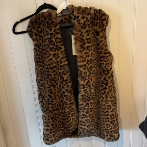 Pälsväst  - Leopard pälsväst med luva! Aldrig använd med lappen kvar. Storlek S men passar även en M!