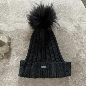 Mössa - Mössa köpt på Raglady, använt skick med lite smink vid pannan. Äkta päls på bollen. Frakt tillkommer.