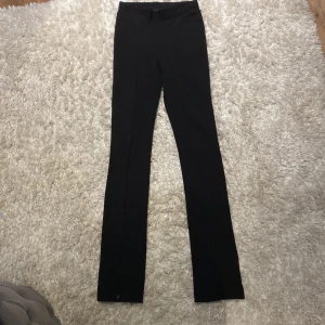 Kostymbyxor bikbok - Svarta kostymbyxor från bikbok, slits på framsidan med dragkedja så du kan schystera själv. Storlek XS men passar mig som är storlek S med