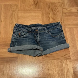 Lågmidjade jeansshorts - Jättefina, lågmidjade jeansshorts köpta i Spanien! Jag är 165cm och brukar ha Xs/S i shorts och dessa sitter jättebra på mig! Midja rakt över: 36cm, midja-gren: 18cm