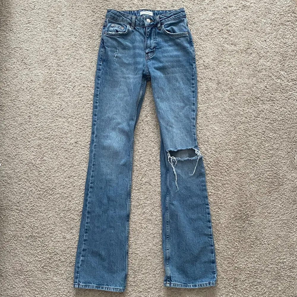 Ett par blåa bootcut jeans från Ginatricot. Sitter midwaist på mig. De är i ganska bra skick. Stl 32 men skulle säga att de passar storlek 34 också. Midjemått: 64 cm, innerbenslängd: 83 cm. Pris kan diskuteras! . Jeans & Byxor.