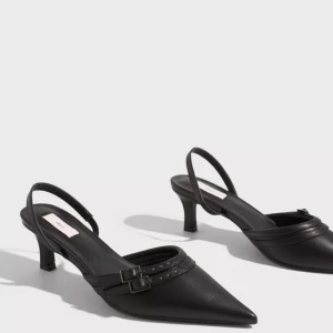 Svarta pumps strl 38 - Aldrig använda Klackskor från Nelly i storlek 38  Spetsig tå. Dekorativt band framtill. Slingback. Klackhöjd 6 cm. Nypris 499 sek