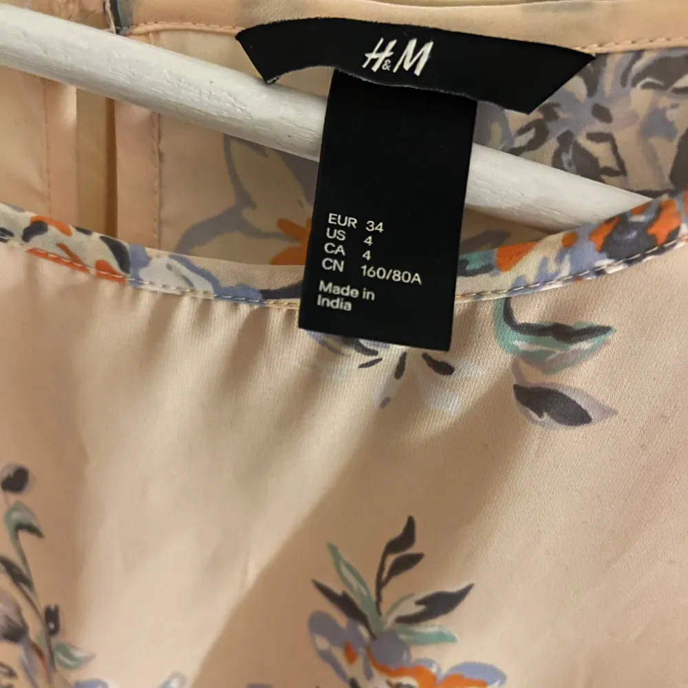 En aprikos blommig klänning med snörning i midjan från H&M i strl 34!💓. Klänningar.
