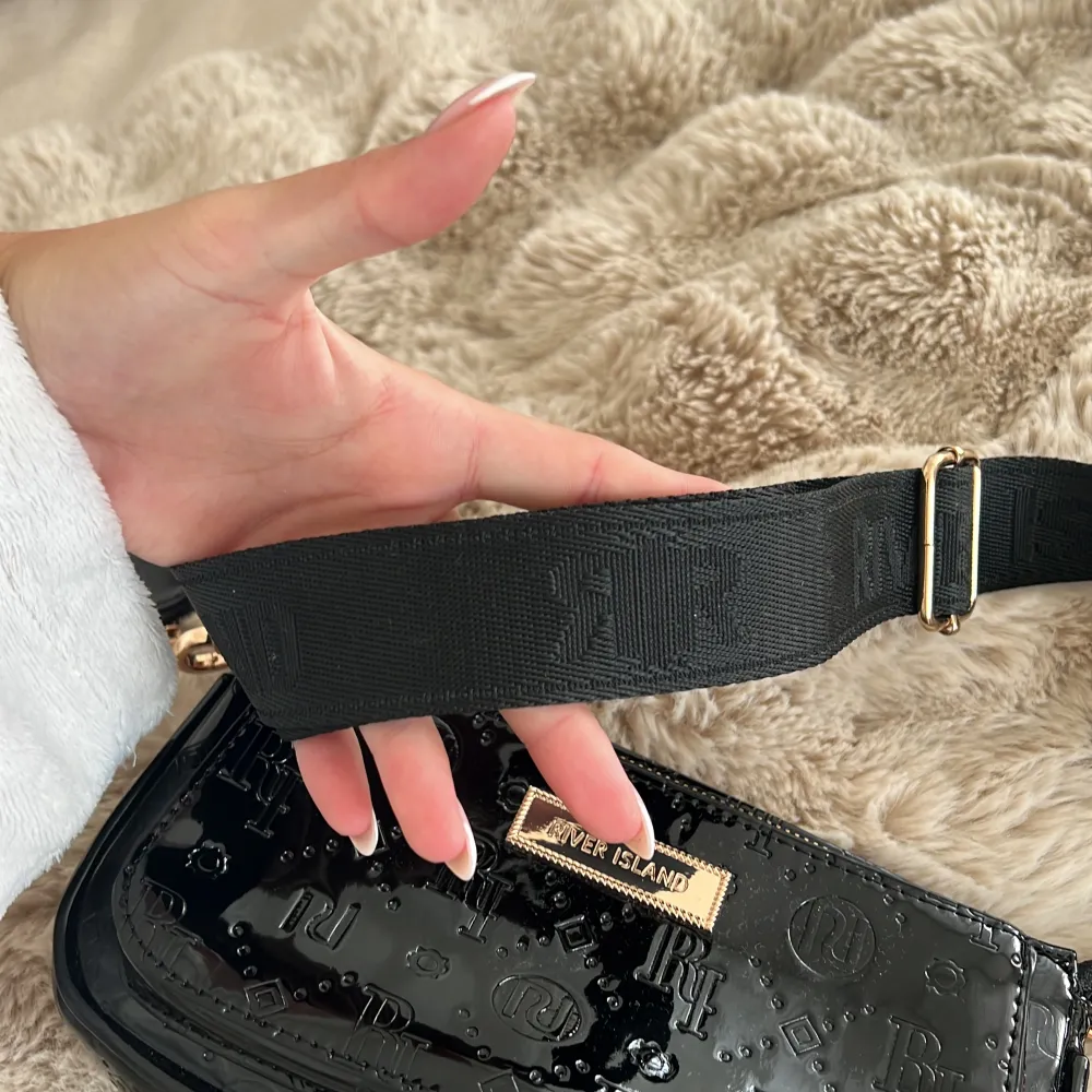 Säljer denna svarta Cross body bag med guld detaljer. Bandet går att reglera längden på. Knappt använd, som ny. Säljer för 350 kr. Köparen står för frakten!. Väskor.