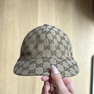 Gucci keps i barn storlek - Storlek 56/ L barn, köpt på NK i Stockholm på Guccis barnavdelning. Nu pris 2850kr på Farfetch. Det blåa på märket är tuschpenna då mina föräldrar skrivit in namn.