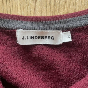 J.Lindberg stickad vinröd - En riktigt fet stickad v-neck från J.Lindberg som är i en vinröd färg. Den är i 100% merinoull. Inga defekter. Passar som S. Hör av er vid några funderingar eller prisförslag😊