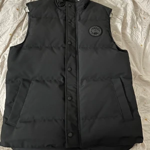 Canada goose väst Äkta black label  - Äkta Canada goose väst, black Label. 100% äkta, köpt på NK och kvitto medföljer. Skick 10/10 knappt använd. Vill sälja eftersom jag bytt stil, skriv för fler bilder. Pris kan diskuteras vid snabb affär!