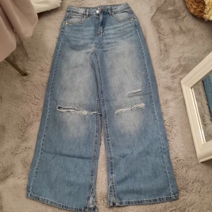 Jeans byxor - Oversized blåa jeans byxor med hål vid knään. De är i jätte fint skick och passar bra för S.