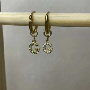 Hoops med strassbokstav - Handgjorda örhängen 18k guldpläterad rostfrittstål. Helt nya. Finns i andra bokstäver också. Fråga gärna i chatten 