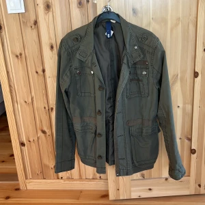 Mörkgrön Field Jacket - Säljer denna feta Field jacket i mörkgrön färg. Storlek S. Skicket är väldigt bra med små tecken på användning. Riktigt bra till vår, sommar o höst. Har du någon fråga eller fundering är det bara att höra av dig!