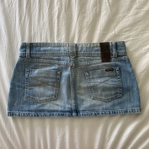 Lågmidjad jeanskjol - Lågmidjad ljusblå jeanskjol. Midjemått 40cm längd bakifrån 28cm, kolla min profil för liknande💕