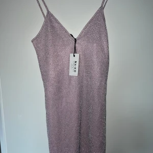 Glittrig klänning  - Fin klänning,aldrig använd endast testad. Lappen finns kvar på klänningen. Justerbara axelband 