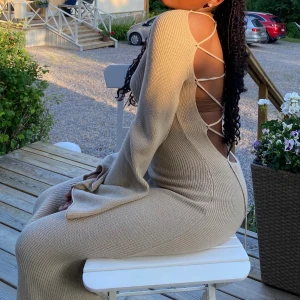 Klänning med korsdetalj och bar rygg - En lång beige strand /sommar klänning, storlek XS (stor i storlek) från NA-KD i jättebra skick, endast använd en gång. Säljer den eftersom det inte är min stil längre. Nypris, 799 SEK, säljs för 580 SEK (pris går att diskutera)!