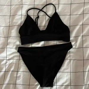 En svart ribbad bikini från H&M. Den är i storlek 36 men lapparna är bortklippta. Säljs pga den inte används. Är i mycket bra skick, knappt använd.