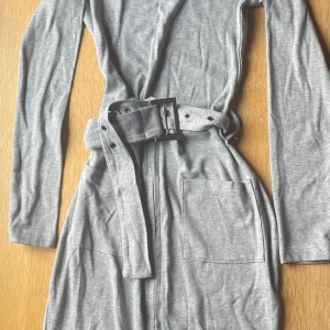 Grå klänning  - Grå lång klänning med dragkedja och bälte. Aldrig använd💗