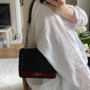 Handväska  - Handvöska från Pauls Boutique London.  Har små slitningar på nitarna, som man ser på bild 2 men inga större skavanker💞