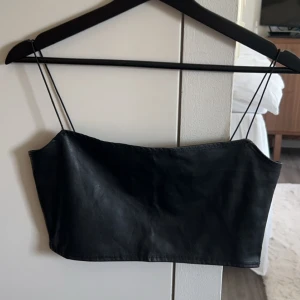 Svart skinntopp - Topp i skinnimitation. Väldigt croppad, använd någon enstaka gång! Säljer även passande kjol till som ett helt set. 🖤skriv vid frågor
